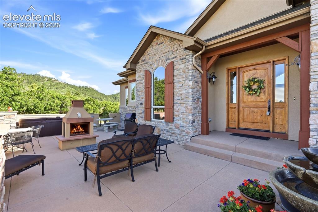 Image 8 of 50: Stone exterior with a wood entry door and sidelights