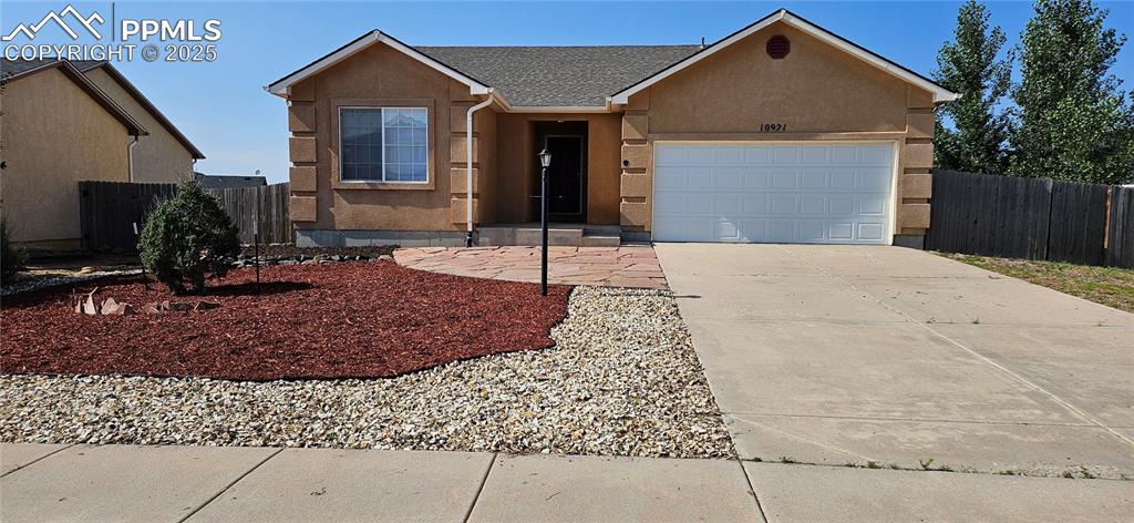 Caption: Ranch-style home with stucco siding, concrete driveway, a garage, and a shingled roof