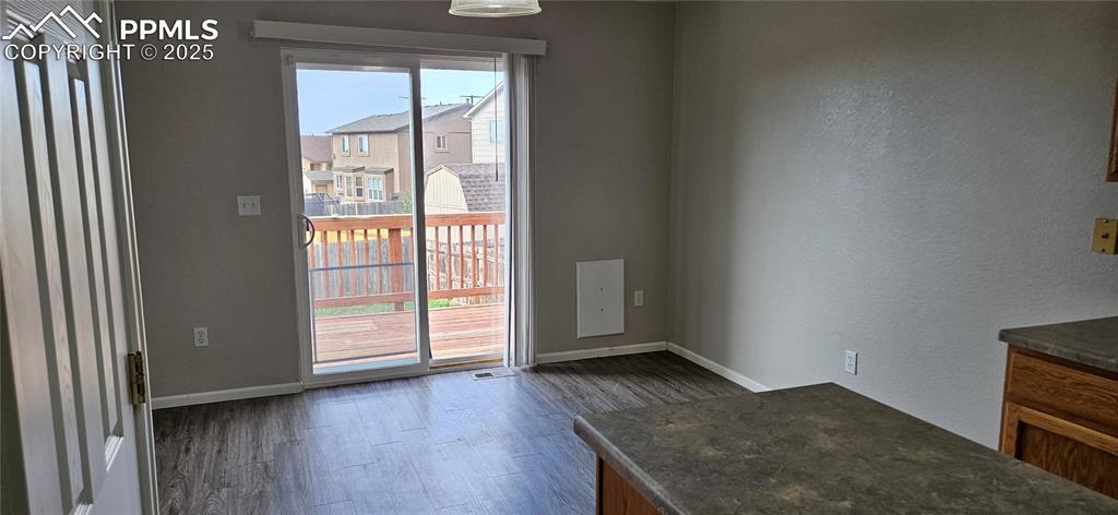 Image 11 of 26: Unfurnished dining area with dark wood-type flooring and a textured wall