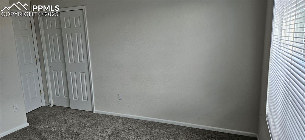Image 17 of 26: Unfurnished 2nd bedroom featuring dark colored carpet and a closet