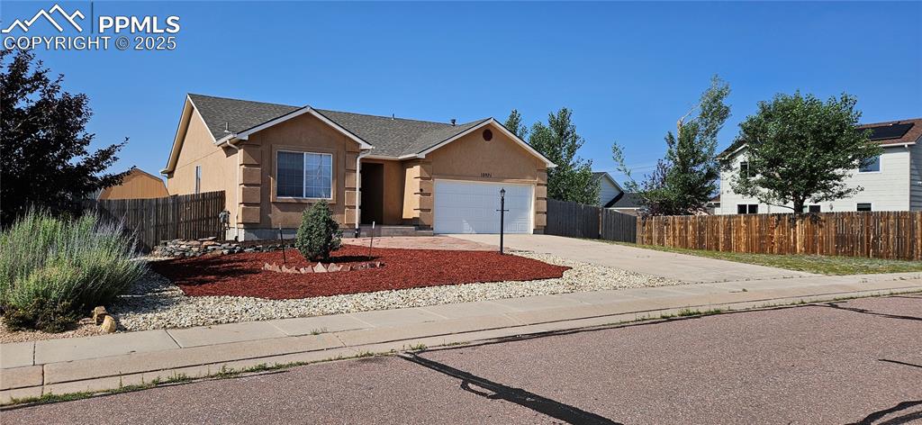 Image 2 of 26: View of front of property featuring stucco siding, an attached garage, driv