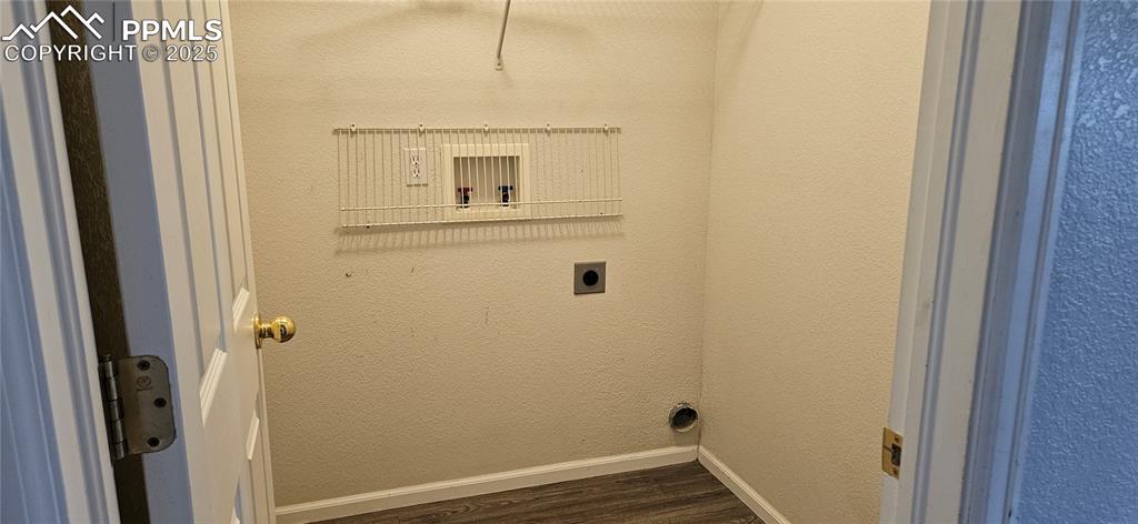 Image 22 of 26: Washroom with electric dryer hookup, dark wood-style flooring, and a textur