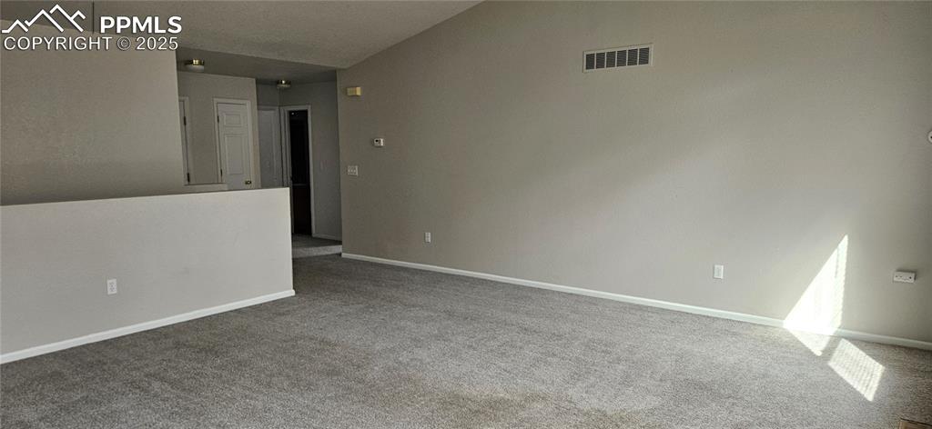 Image 7 of 26: Unfurnished room with carpet flooring and lofted ceiling