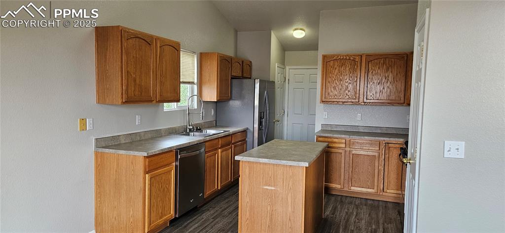 Image 8 of 26: Kitchen featuring dark wood-style flooring, a center island, stainless stee