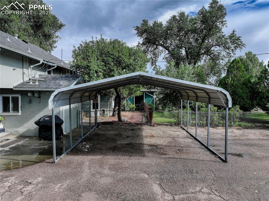 Image 14 of 50: View of vehicle parking with a carport 