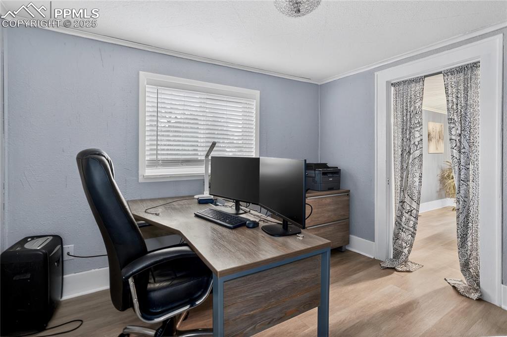 Image 42 of 50: Office area featuring crown molding and wood finished floors (Can also be u