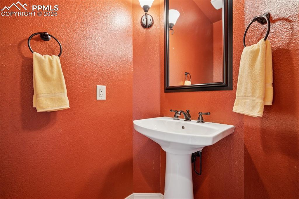 Image 19 of 47: Main level 1/2 Bathroom featuring a sink and a textured wall