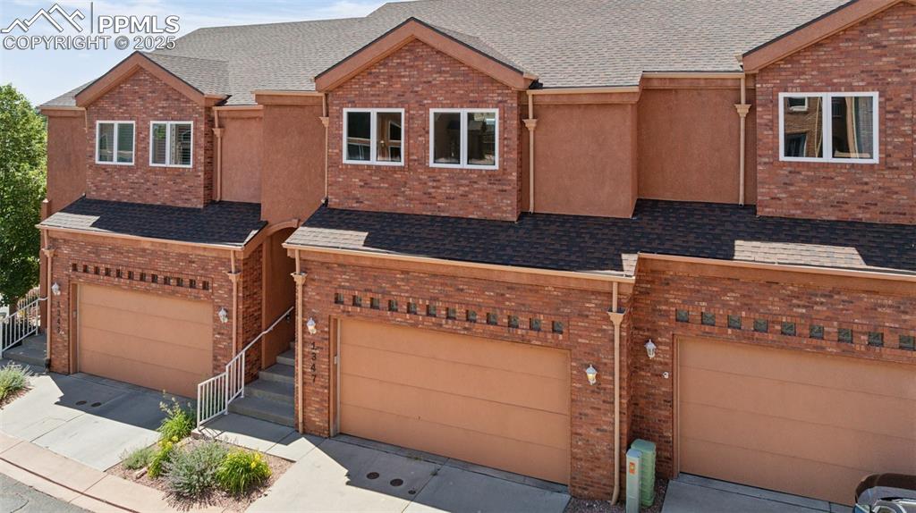 Image 2 of 47: View of front facade with an attached garage, brick siding, driveway, and r