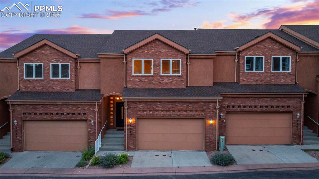 Image 33 of 47: View of front facade featuring a garage, concrete driveway, and brick sidin