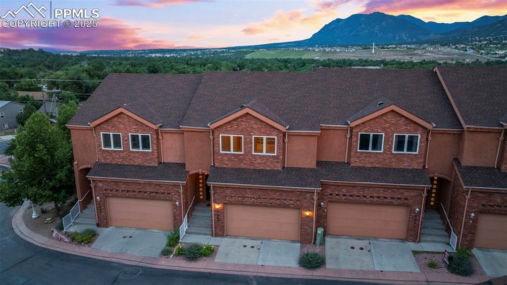 Image 34 of 47: Multi unit property featuring brick siding, a mountain view, and a garage