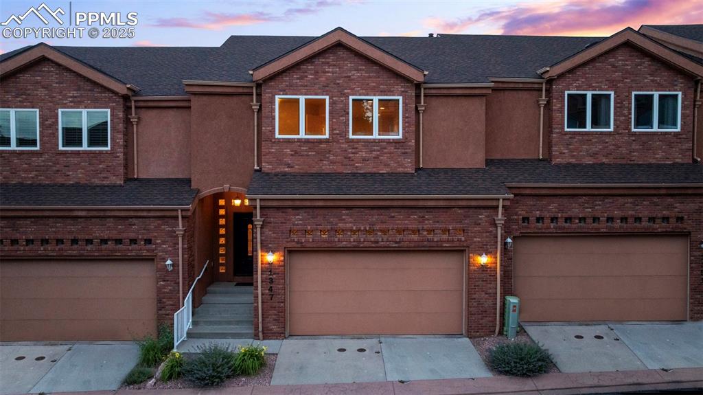 Image 39 of 47: View of front facade featuring brick siding, a garage, and driveway