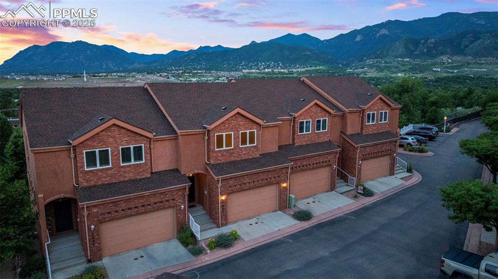 Image 40 of 47: View of front facade featuring a garage, a mountain view, a shingled roof, 