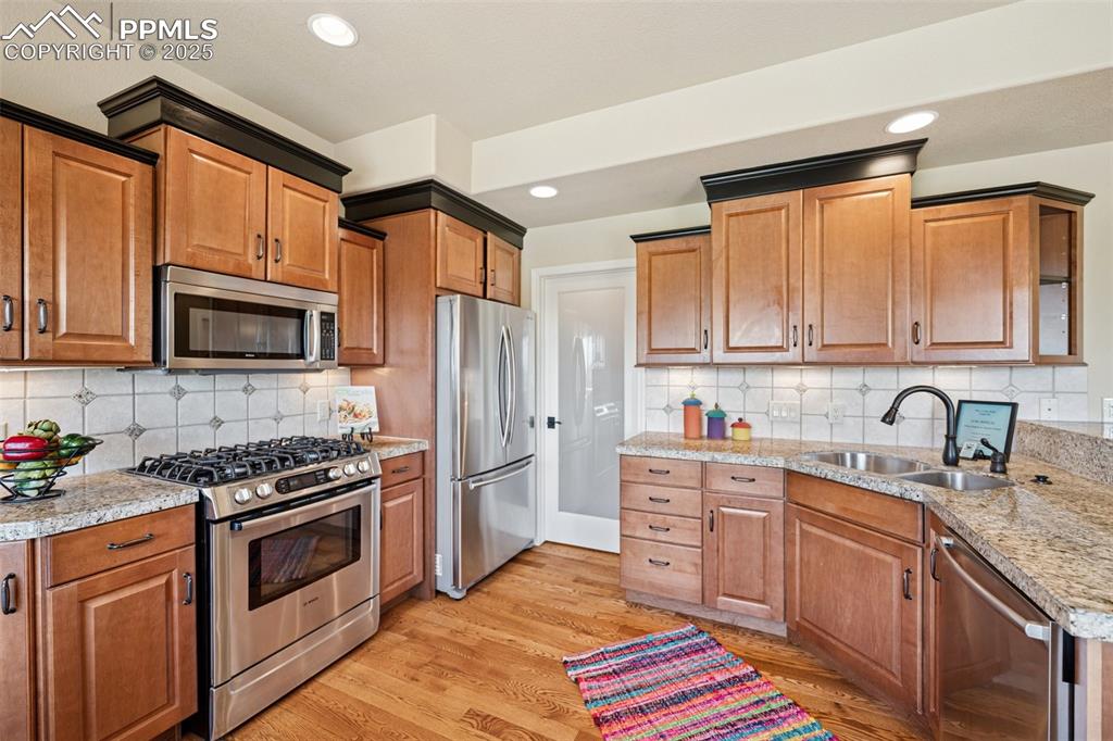 Image 7 of 47: Kitchen with appliances with stainless steel finishes, light wood-style flo