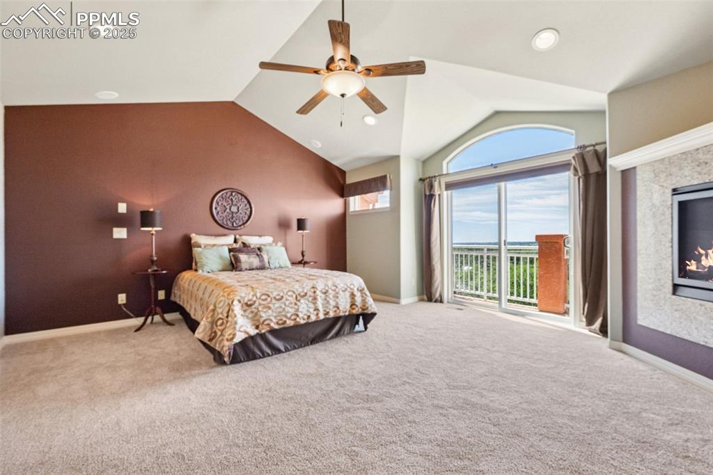 Image 8 of 47: Bedroom with lofted ceiling, access to outside, carpet, a ceiling fan, and 