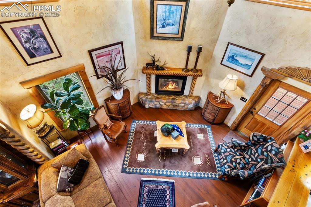 Image 13 of 50: Living area with hardwood / wood-style flooring and a glass covered firepla