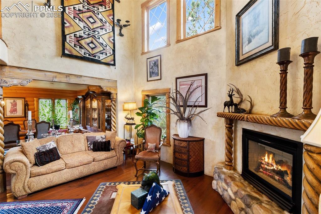 Image 14 of 50: Living area with a high ceiling, hardwood / wood-style flooring, a glass co