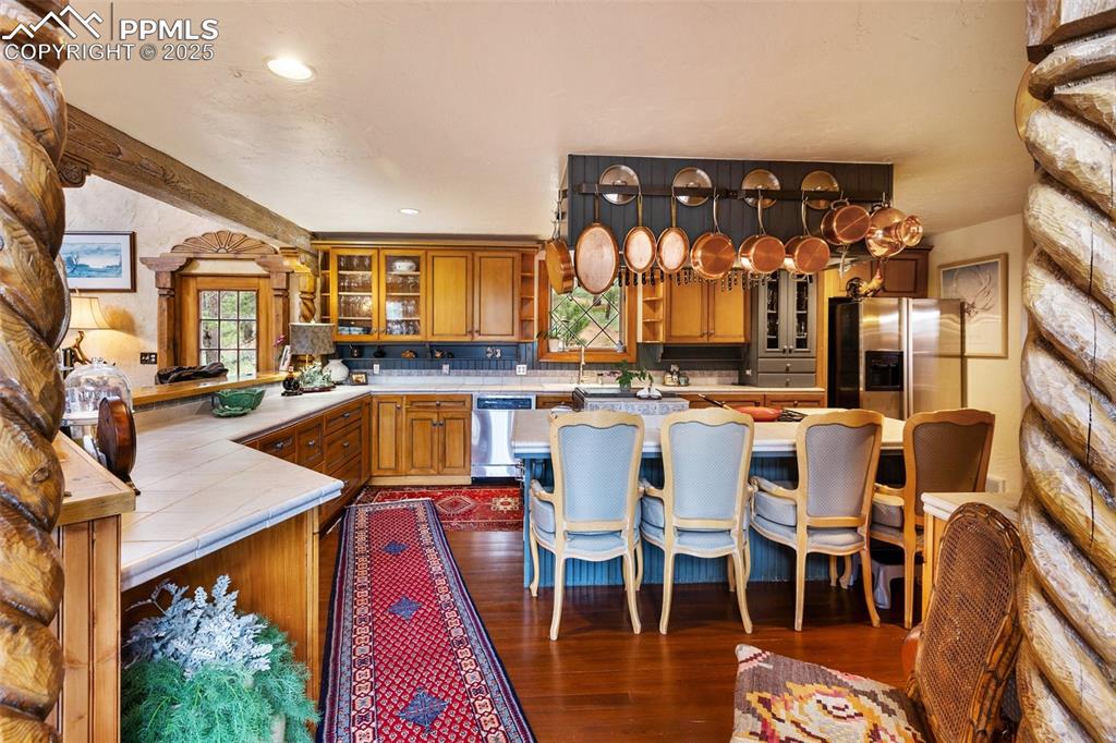Image 15 of 50: Kitchen featuring appliances with stainless steel finishes, tile counters,