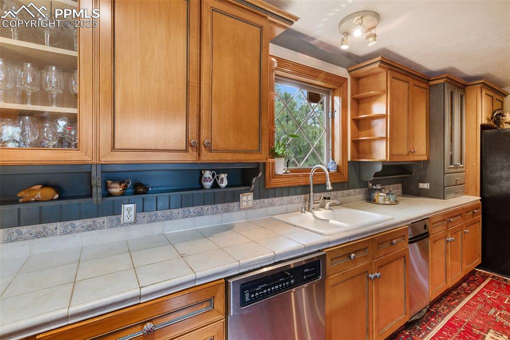 Image 16 of 50: Kitchen featuring dishwasher, open shelves, freestanding refrigerator, and