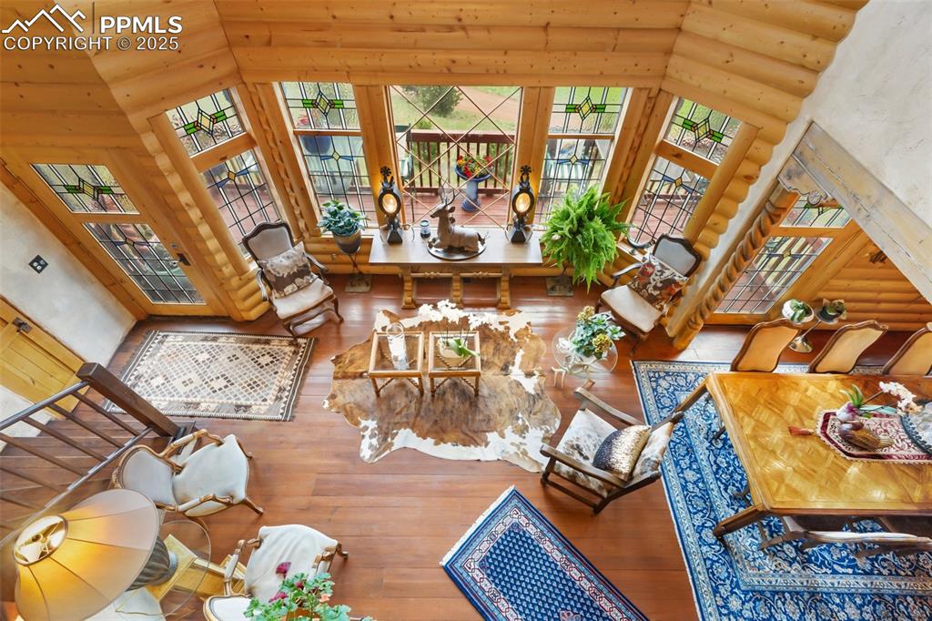 Image 24 of 50: Living room featuring log walls, hardwood / wood-style flooring, and a high