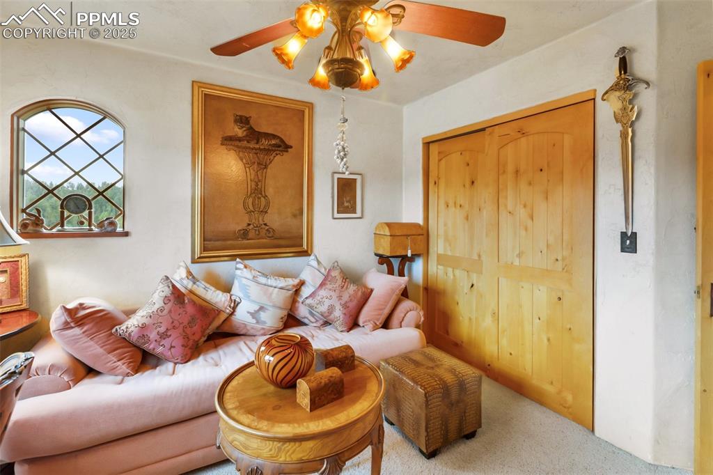 Image 28 of 50: Carpeted living area with a ceiling fan