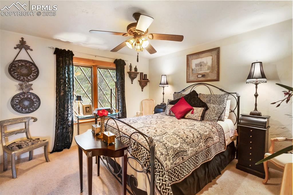 Image 31 of 50: Bedroom with light carpet and a ceiling fan