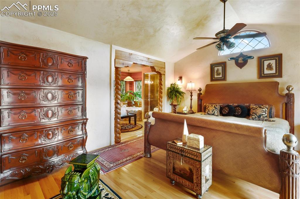 Image 36 of 50: Bedroom with light wood finished floors, vaulted ceiling, and ceiling fan