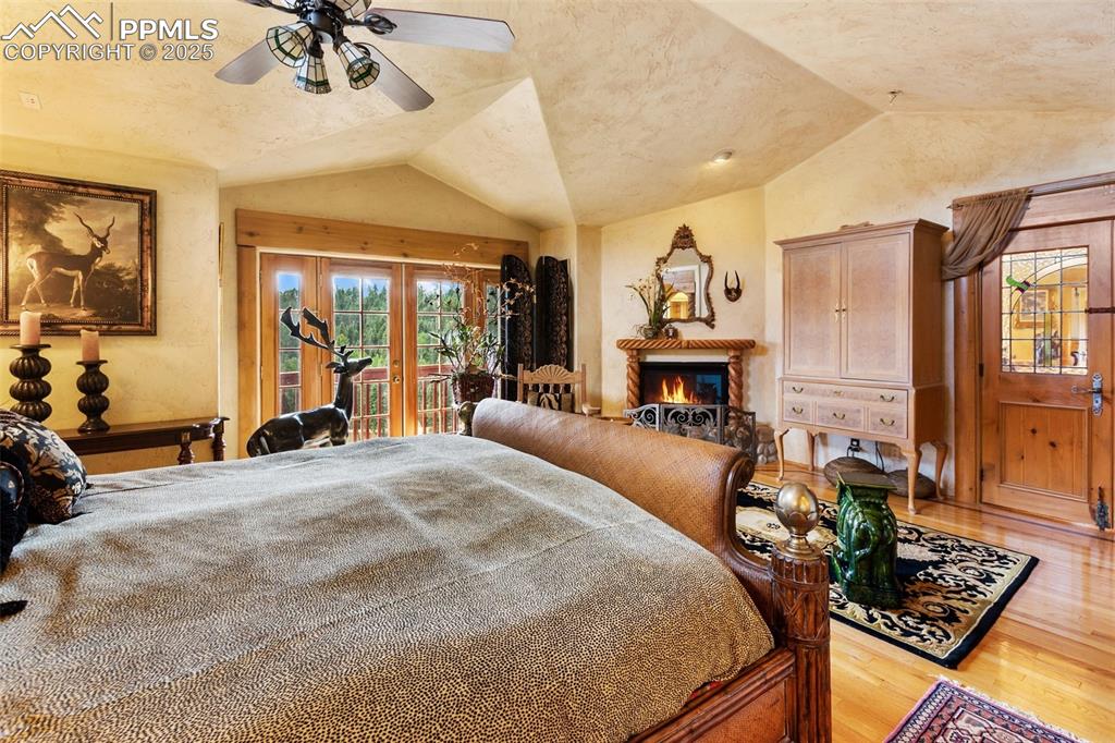 Image 38 of 50: Bedroom with lofted ceiling, french doors, access to outside, wood finished