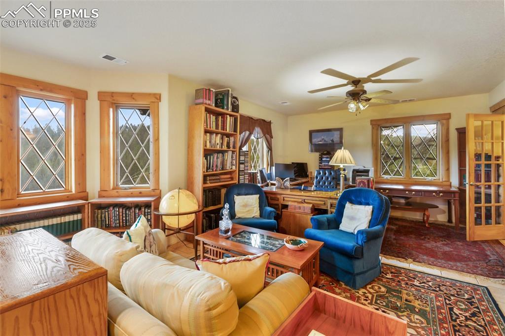 Image 41 of 50: Living room with healthy amount of natural light, a ceiling fan, and an off
