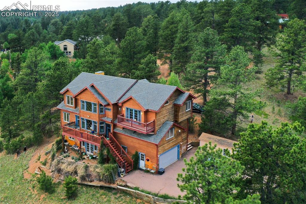 Image 47 of 50: Aerial view of property and surrounding area featuring a heavily wooded are