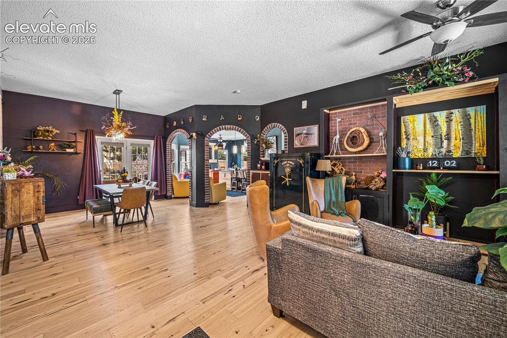 Image 15 of 50: Vaulted ceiling with a ceiling fan, light wood-finish flooring, dark wood w