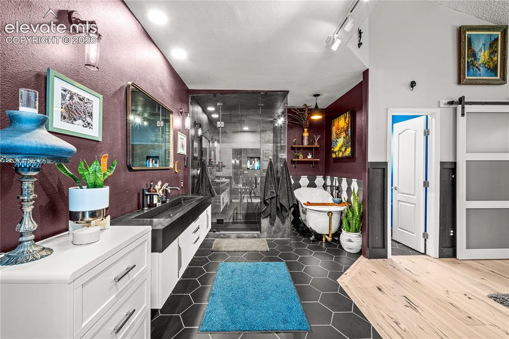Image 21 of 50: Exposed brick accent wall, light wood-finish flooring, custom wood island w