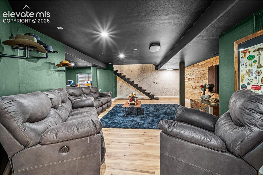 Image 33 of 50: Recessed lighting illuminates the space, featuring wood-finish flooring and