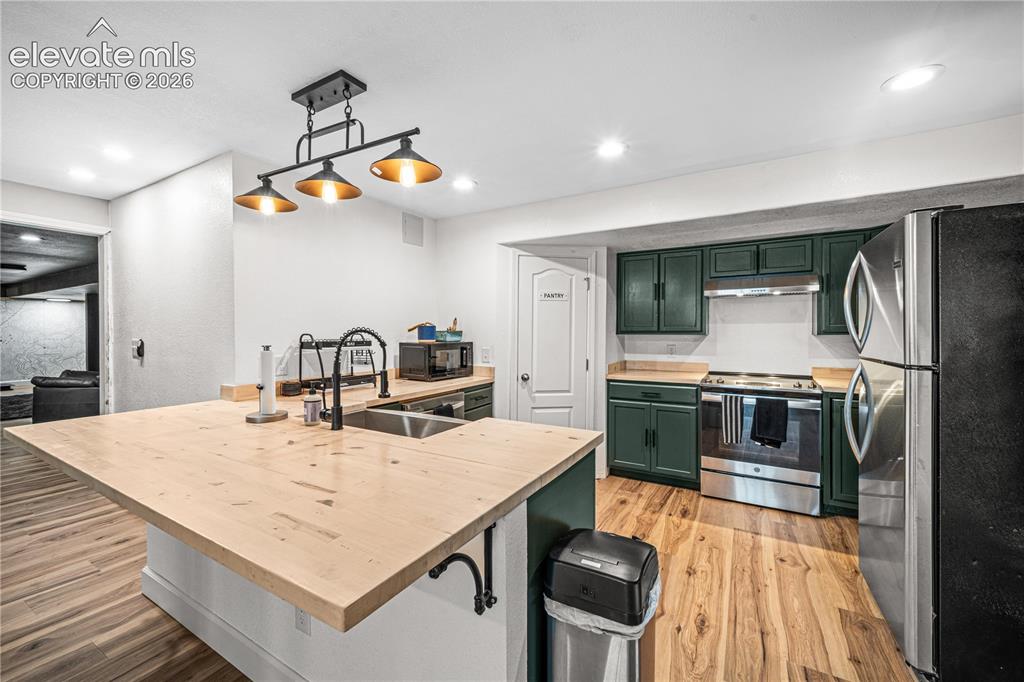 Image 35 of 50: Wood-finish flooring, accent wall with horizontal wood paneling, open-tread