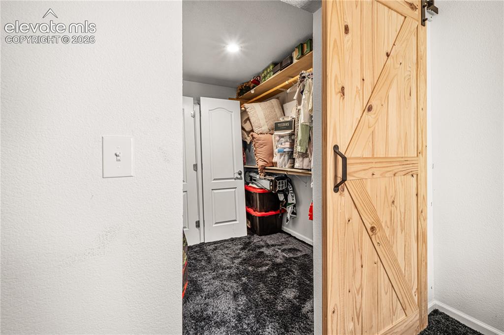 Image 42 of 50: Neutral wall paint, a ceiling fan with integrated lighting, and dark carpet