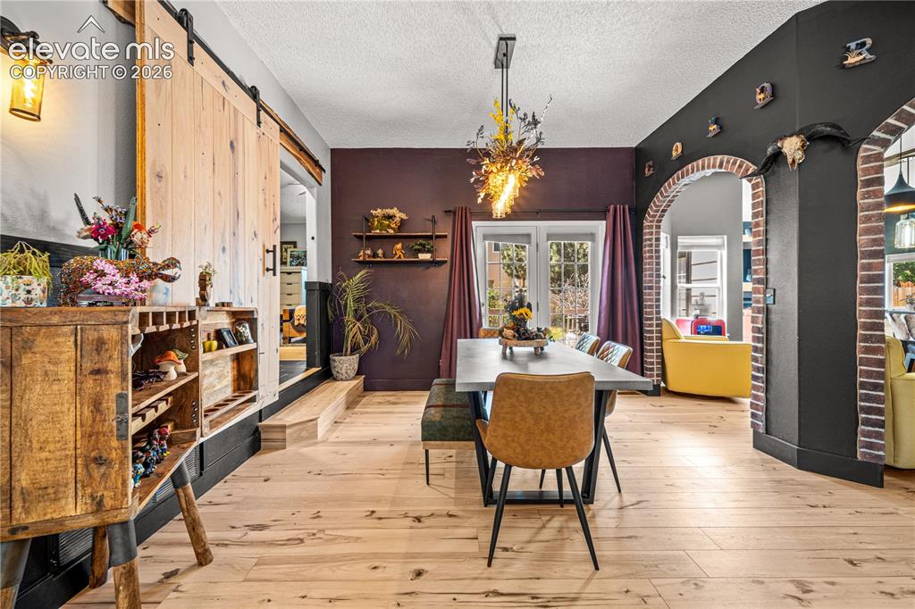 Image 7 of 50: Wood-finish flooring throughout, with a decorative light fixture, and Frenc