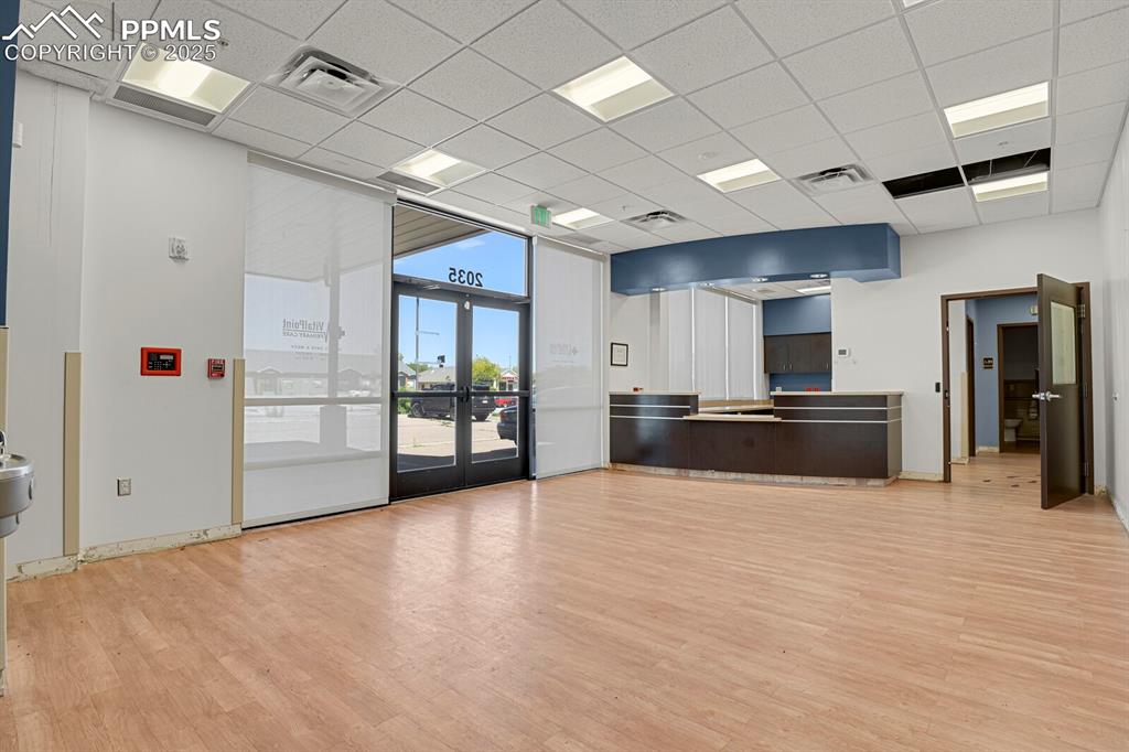 Image 11 of 43: Welcome area with a paneled ceiling, french doors, and floor to ceiling win