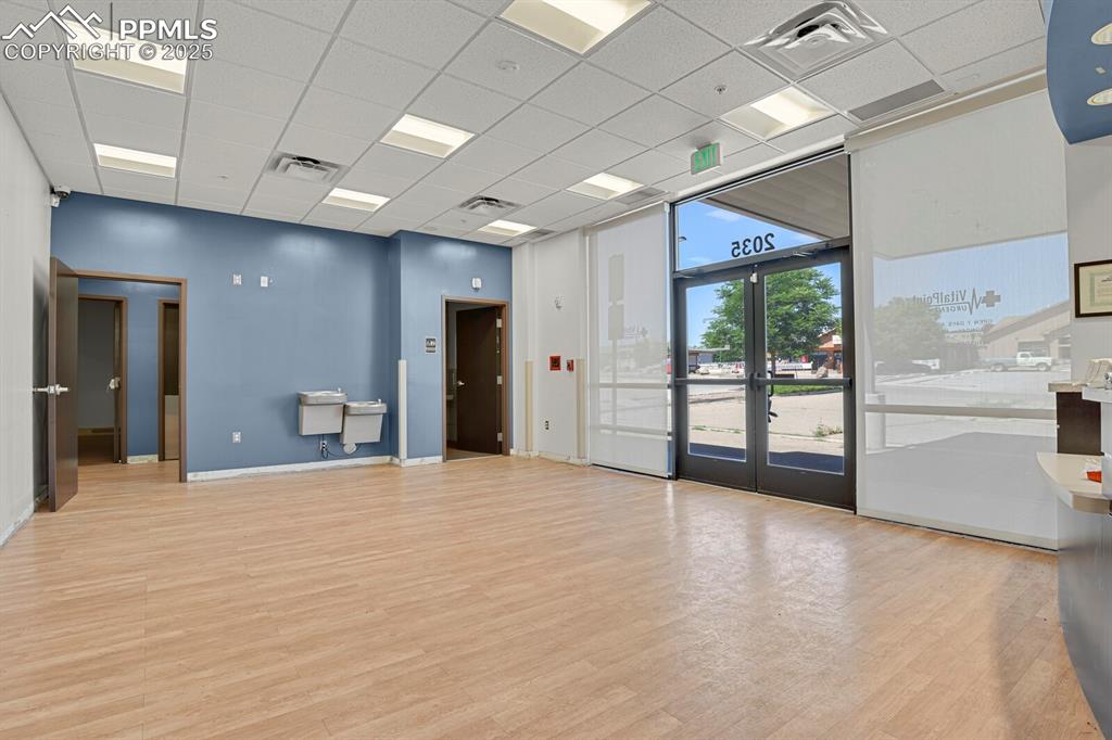 Image 3 of 43: Unfurnished room with a drop ceiling, light wood-style floors, and french d
