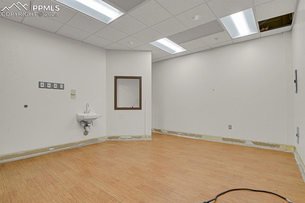 Image 7 of 43: Unfurnished room with light wood-type flooring and a drop ceiling