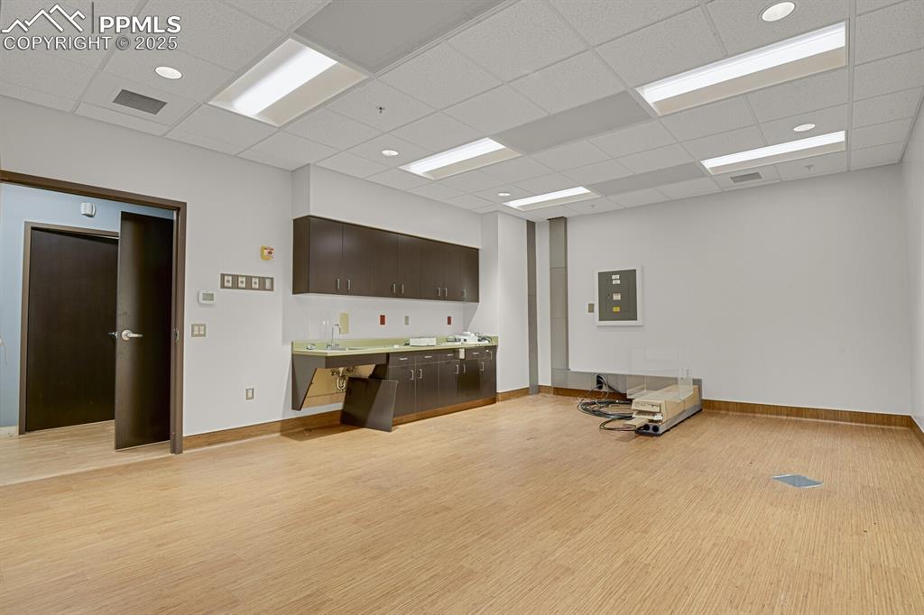 Image 8 of 43: Miscellaneous room with a drop ceiling and electric panel