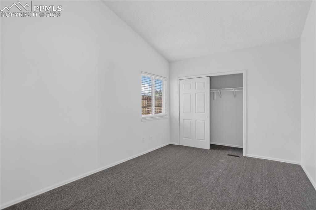 Image 9 of 17: Primary bedroom w/ vaulted ceiling