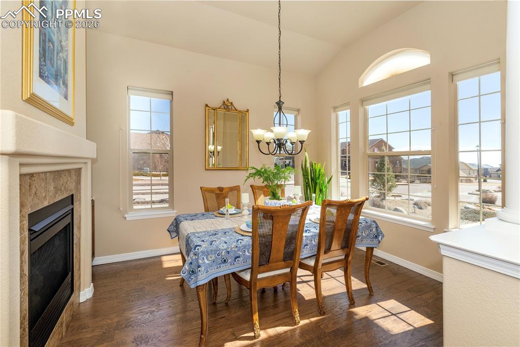 Image 15 of 50: Sunroom-inspired dining area with a vaulted ceiling and an abundance of nat
