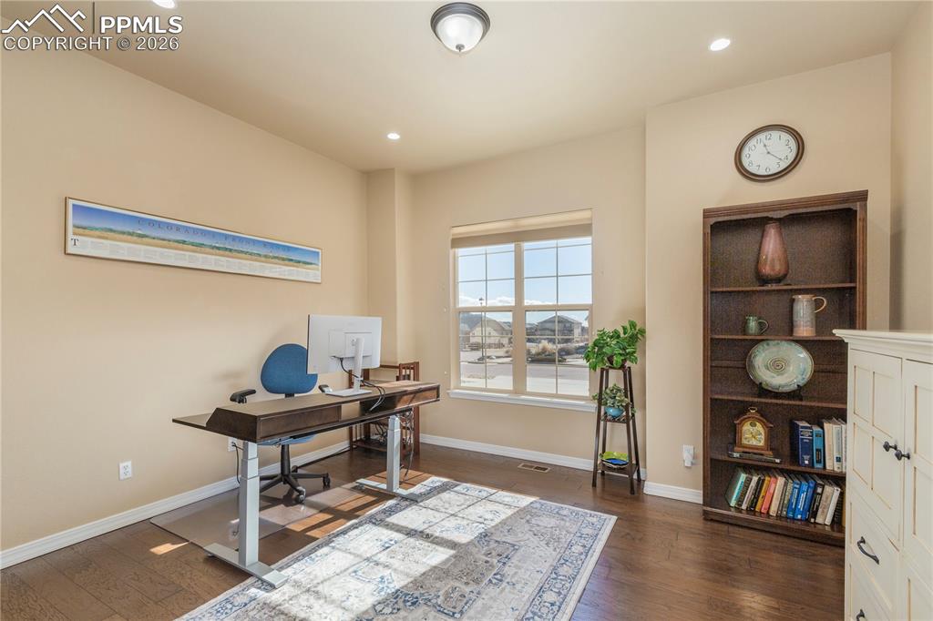 Image 29 of 50: Office space with dark wood-type flooring and recessed lighting