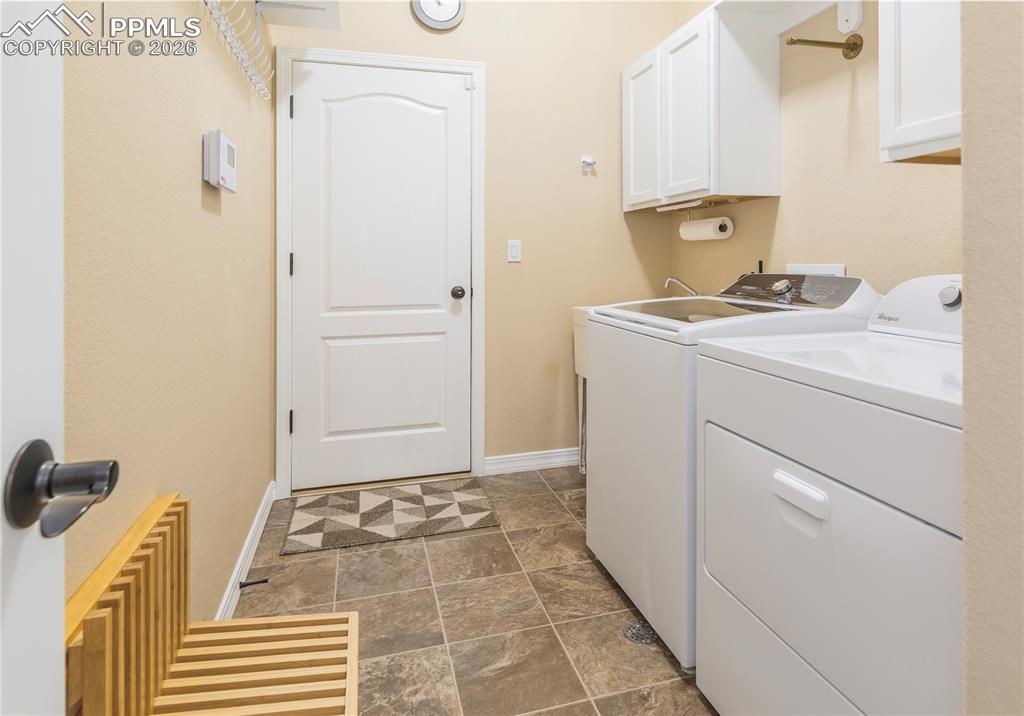 Image 44 of 50: Laundry room features overhead storage, Whirlpool washer (2026) and dryer (