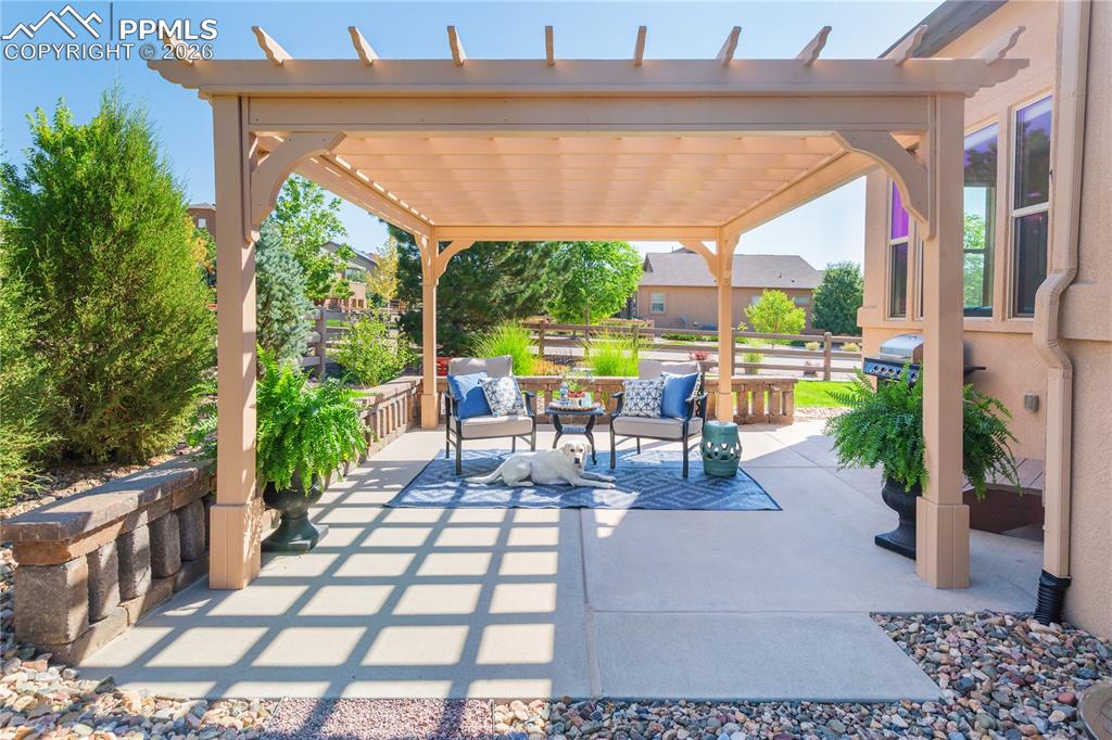 Image 5 of 50: Expanded patio with custom pergola and outdoor lounge area.