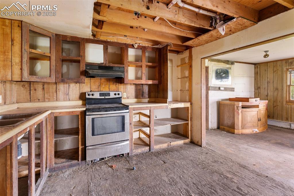 Image 10 of 36: Kitchen featuring stainless steel range with electric stovetop, under cabin
