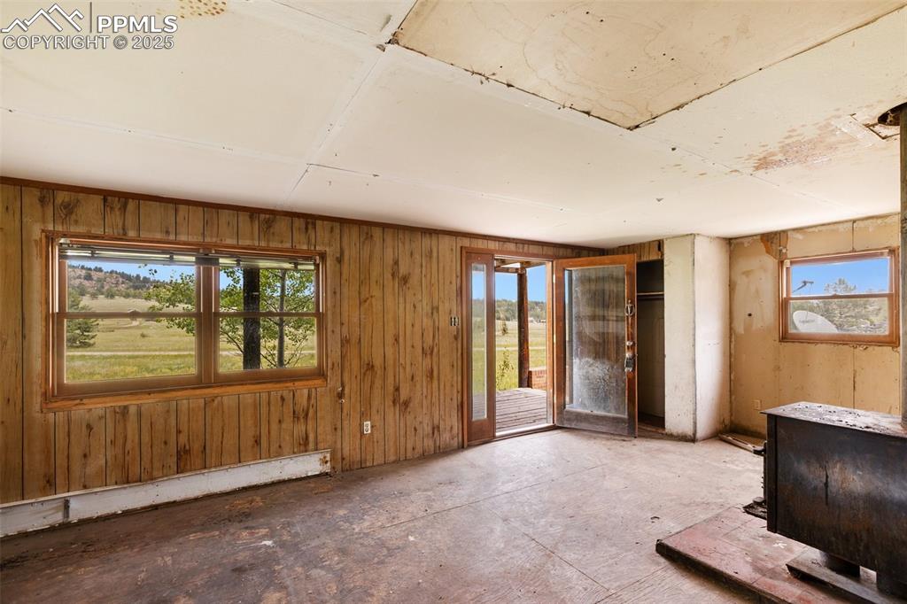 Image 17 of 36: Miscellaneous room with healthy amount of natural light, wood walls, and a