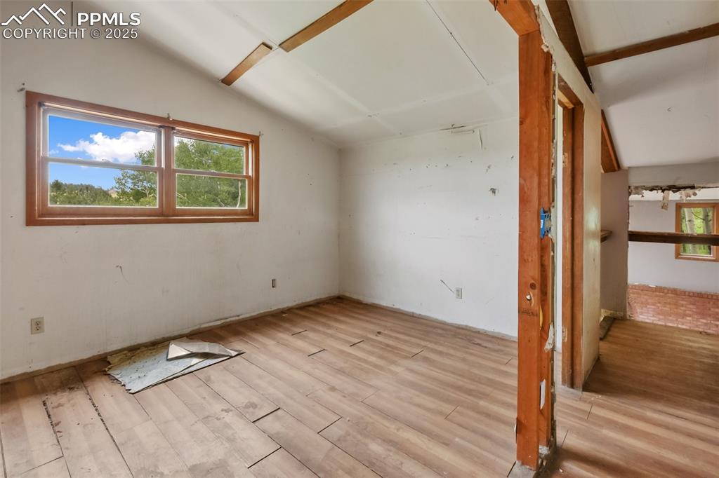 Image 20 of 36: Additional living space featuring lofted ceiling and wood finished floors