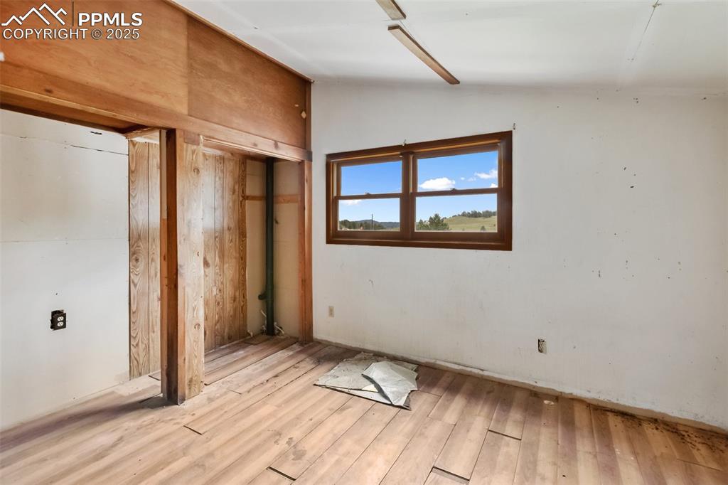 Image 24 of 36: Unfurnished bedroom featuring light wood-style flooring, vaulted ceiling, a