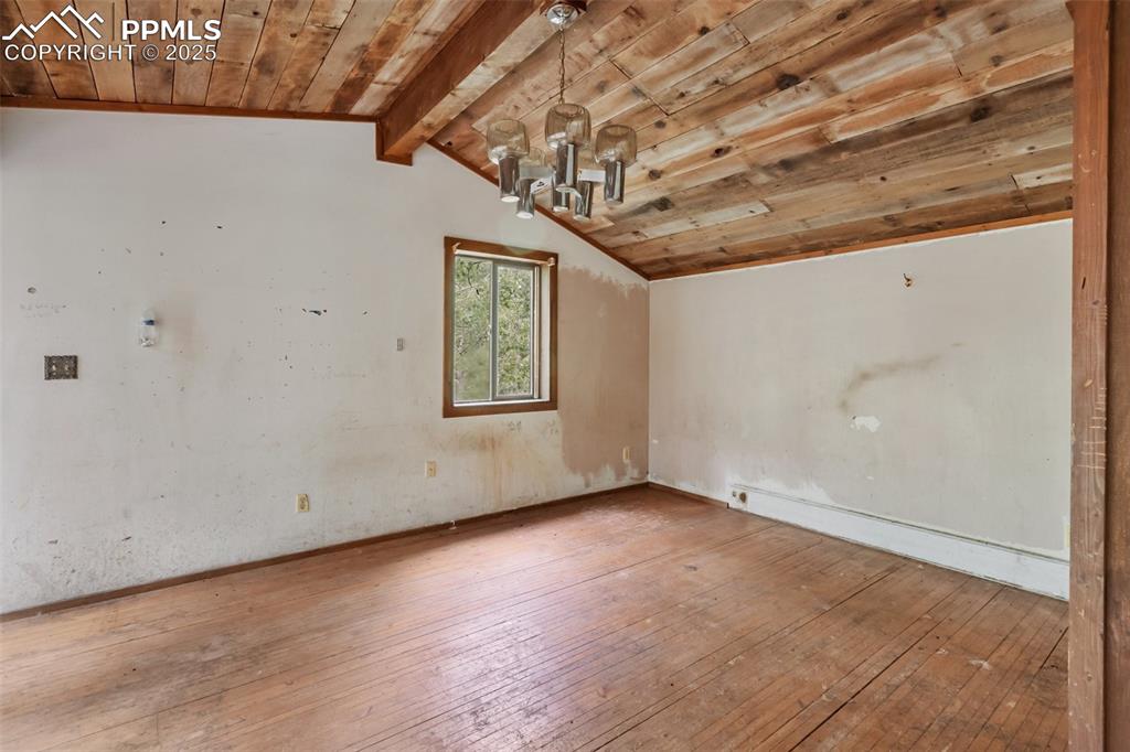 Image 25 of 36: Bonus room featuring a chandelier, wooden ceiling, and wood-type flooring