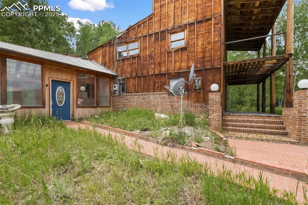 Image 27 of 36: View of side of property featuring board and batten siding and a metal roof